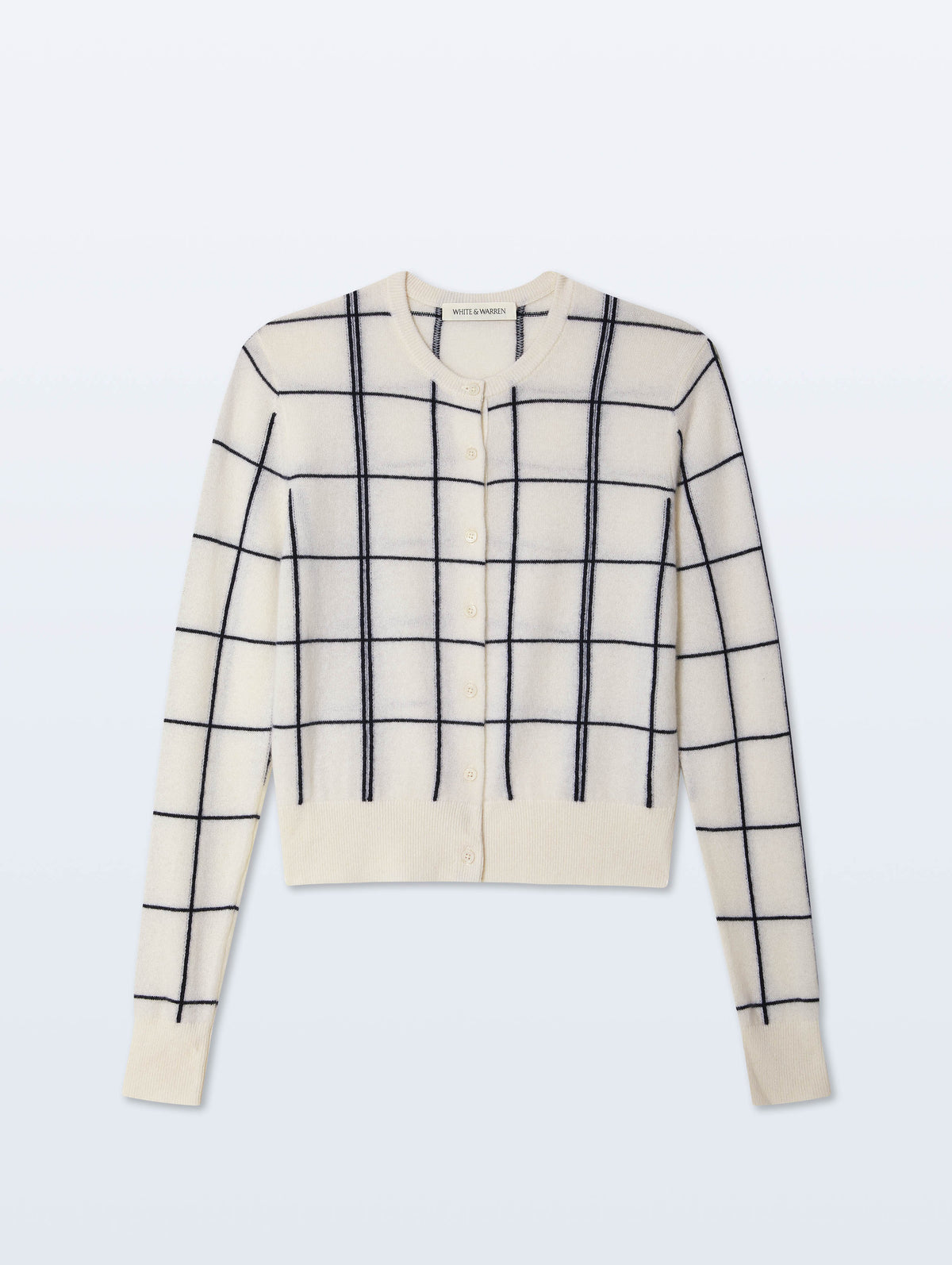 The White + Warren Cashmere Windowpane Cardigan features a cream color with black windowpane intarsia knit, straight fit, button front, and ribbed cuffs and hem, shown laid flat on a light background.