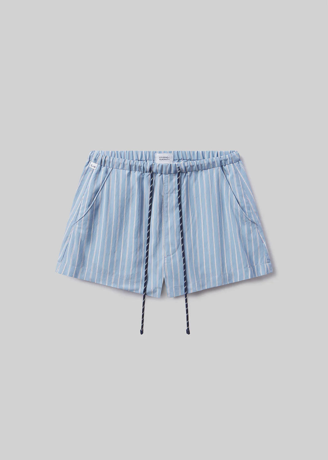 The este drawstring short in capri stripe by Citizens Of Humanity/AGOLDE features light blue and white vertical stripes, an elastic waistband, navy drawstrings, and side pockets. Shown on a plain light gray background—perfect for everyday comfort.