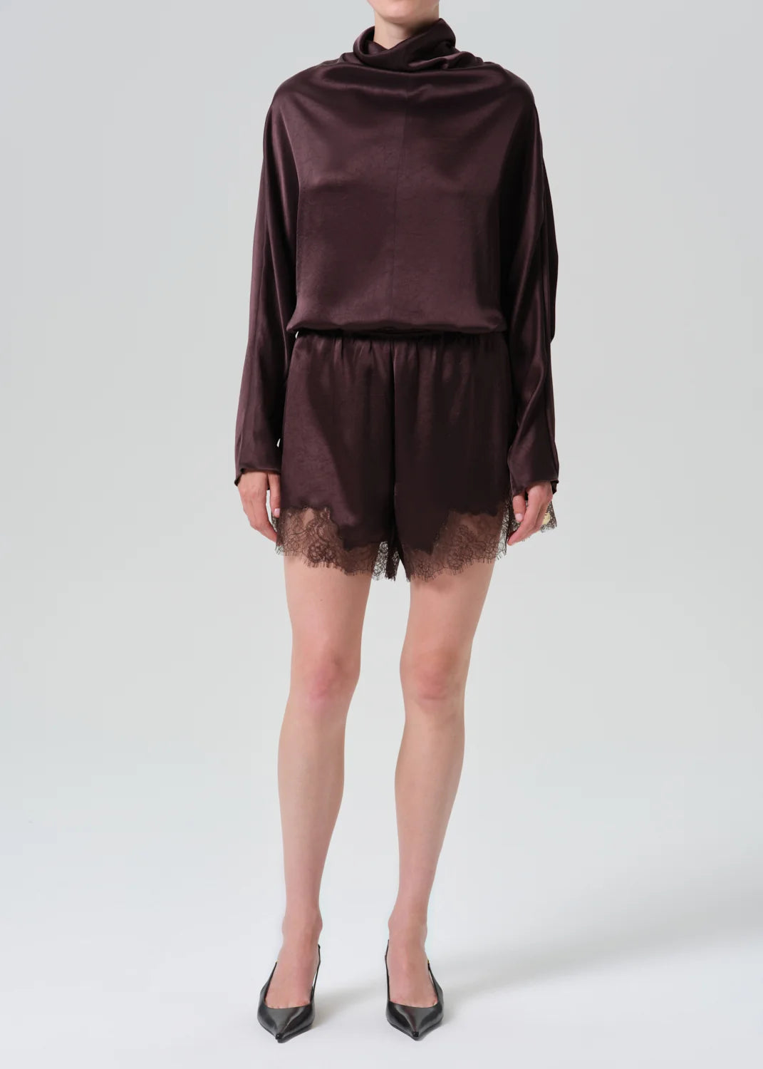 Lace trimmed tap shorts by Citizens of Humanity, paired with a satin long-sleeve top and black heels.