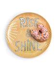 Sugarboo Designs' The Breakfast Club Plate Set features a round plate with "RISE & SHINE" and sun rays, served with a pink frosted sprinkled donut—a true Breakfast Of Champions.