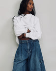 Denimist AINSLEY triple pleat cargo shorts in denim blue, shown outdoors styled with a casual look.