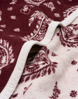 Faire Palmer Paisley Blanket with maroon and white paisley pattern, finished with a white trim.