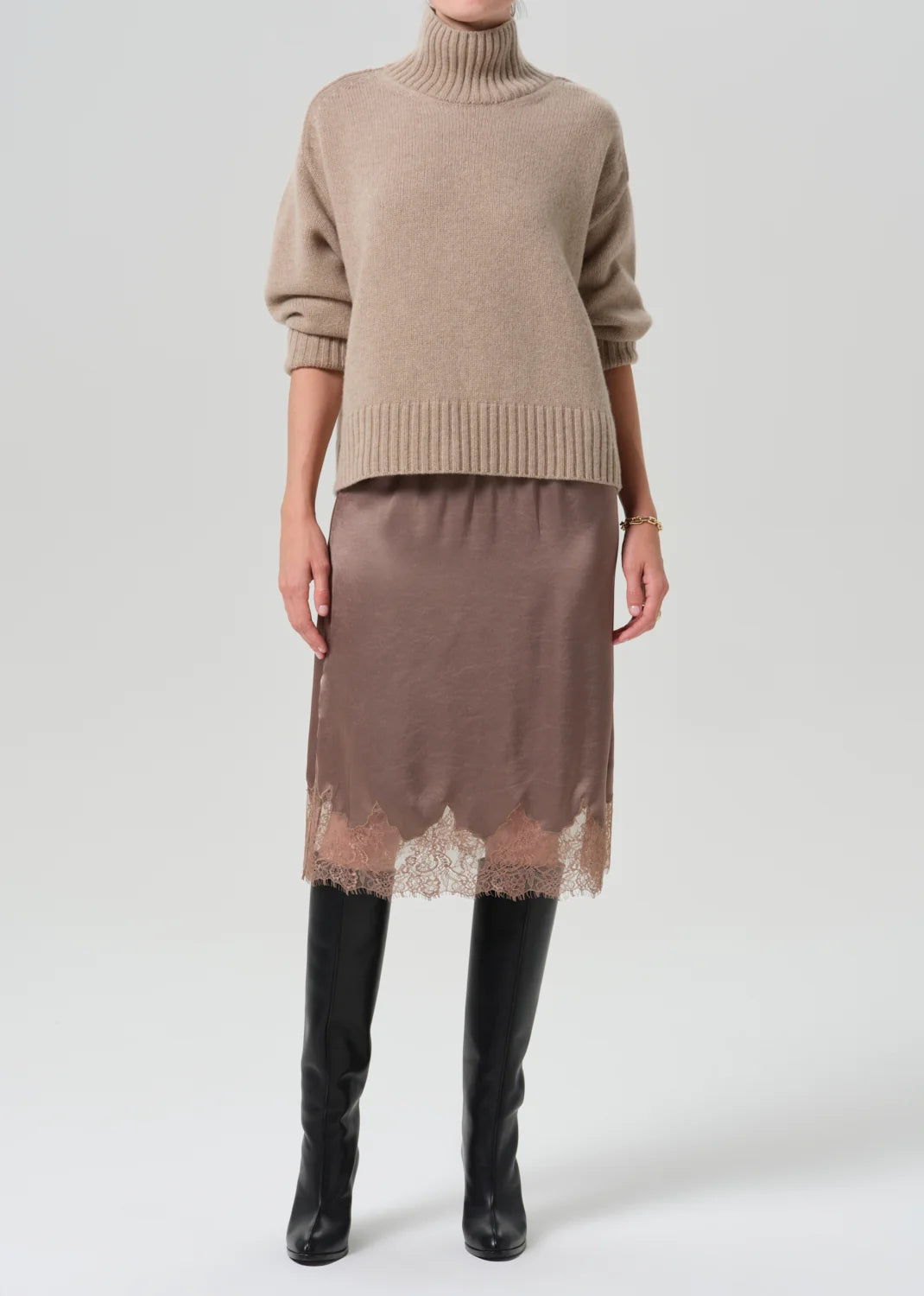 Citizens Of Humanity lace trimmed beige skirt styled with a turtleneck and black knee-high boots.
