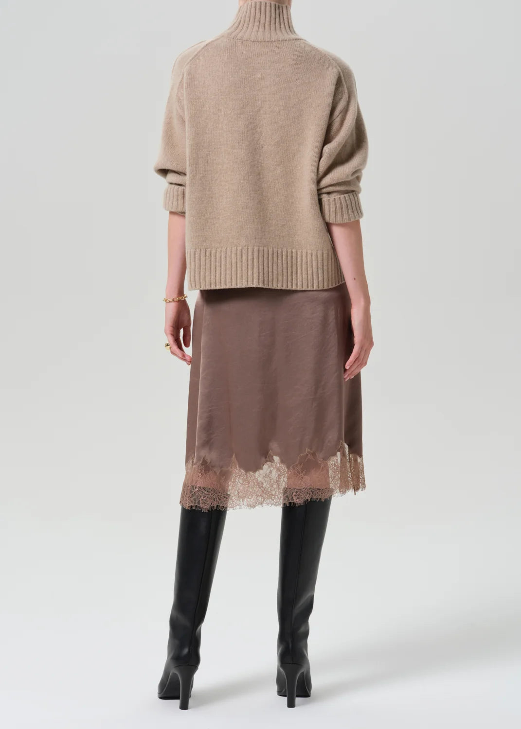 Lace trimmed skirt by Citizens of Humanity/AGOLDE styled with beige turtleneck and black knee-high boots.