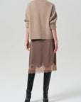 Lace trimmed skirt by Citizens of Humanity/AGOLDE styled with beige turtleneck and black knee-high boots.