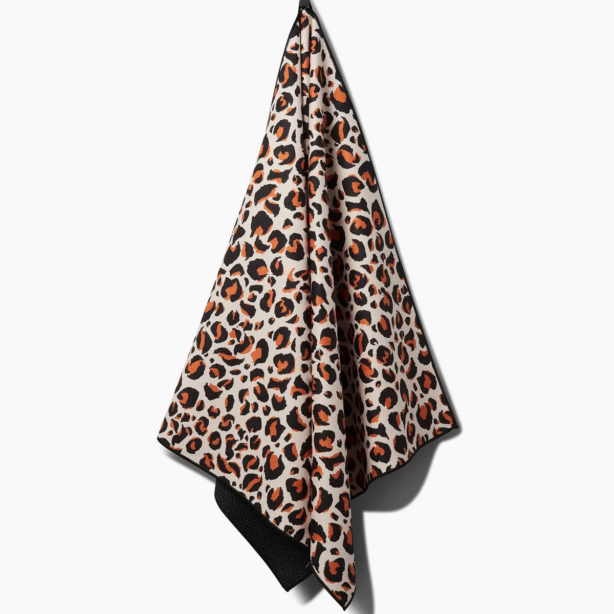 The Faire Leopard Yoga Towel features a bold orange, black, and beige leopard print and ultra-absorbent fabric, shown hanging from a hook against a white background.