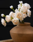 Cream ranunculus bouquet in a rounded terracotta-style vase by Bungalow Furniture & Accessories.