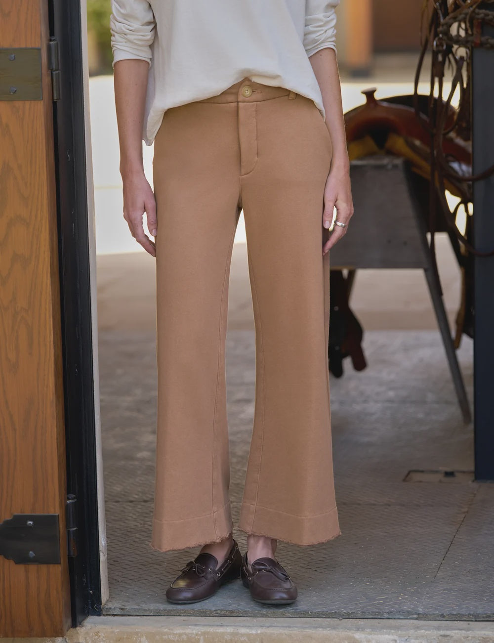 Frank & Eileen Riley wide leg trousers styled with a white top and brown loafers in a doorway setting.
