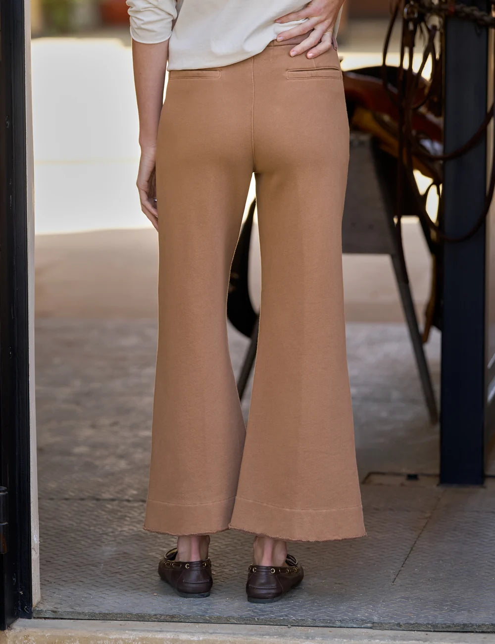 Wide leg Frank & Eileen Riley trousers in brown, seen from the back as worn in a doorway, casual lifestyle setting.