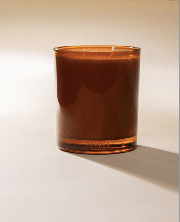 Brown glass Faire Palomino candle with white wick by Bungalow Furniture, styled on a crisp white background.