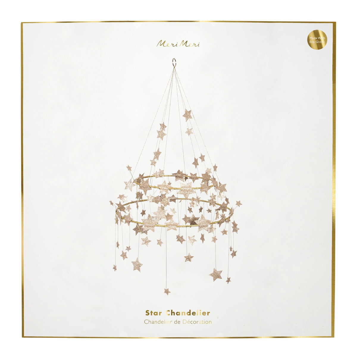 The Gold Sparkle Star Chandelier by Faire comes in a decorative box with a pajaki-inspired illustration of a hanging star chandelier, gold glitter stars, and “Gold Sparkle Star Chandelier” written in gold text, framed with a thin gold border.