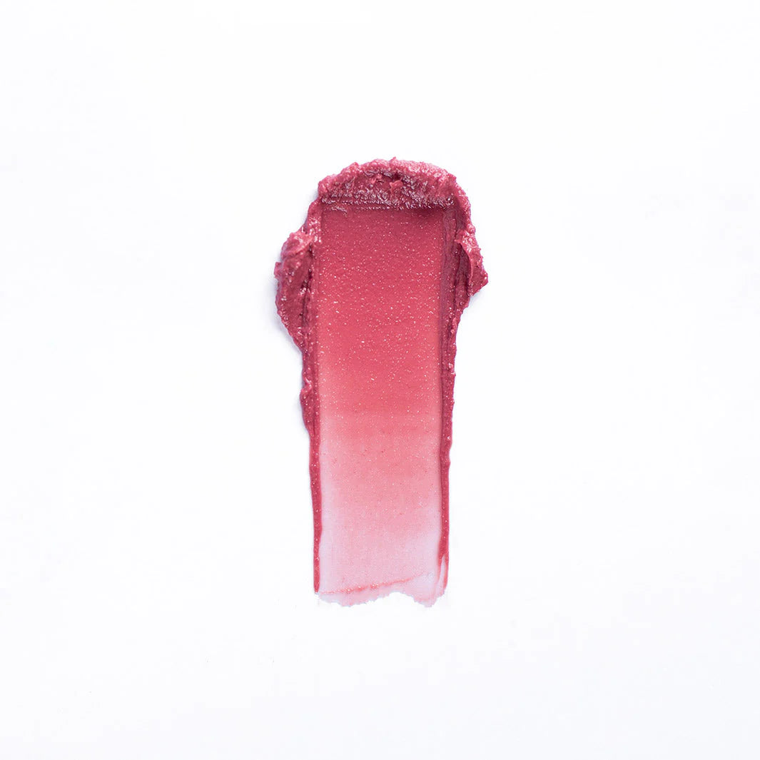 A vertical swatch of Faire 02-Tinted Lip Balm & Blush in mauve pink appears on a white background, displaying its smooth, hydrating formula with a dark-to-light gradient.