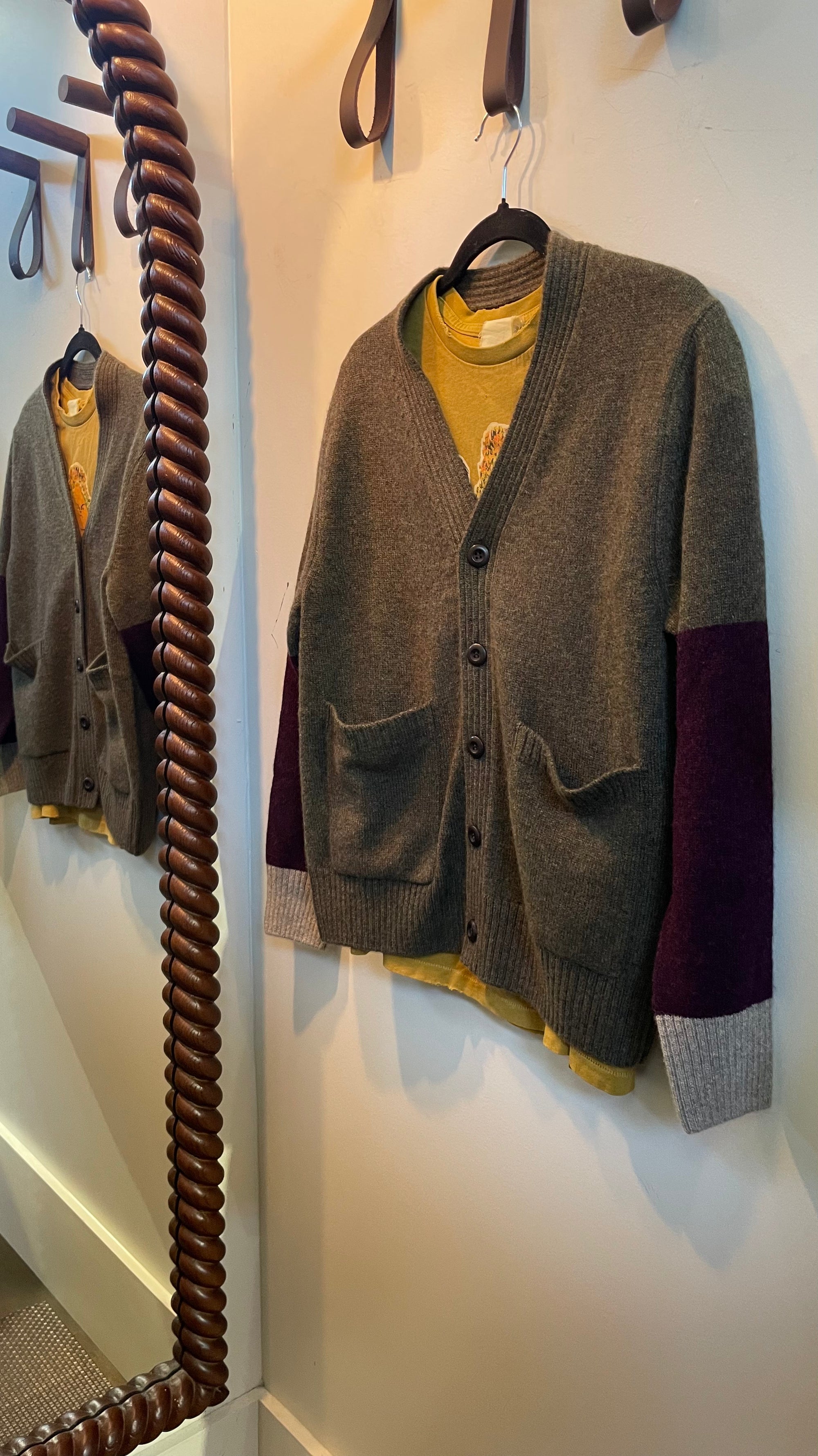 Gray and purple colorblock cashmere button-front cardigan by Free City, hanging by a mirror.