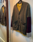 Gray and purple colorblock cashmere button-front cardigan by Free City, hanging by a mirror.