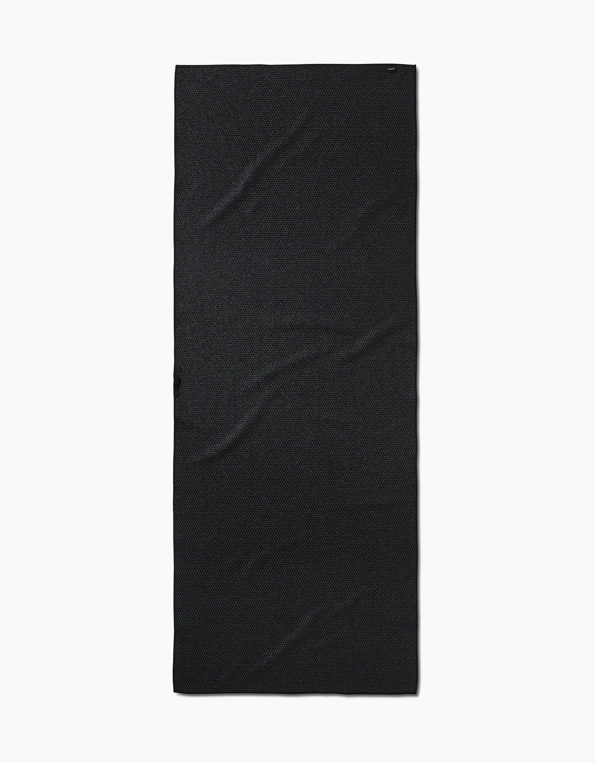 The Faire Chic Checker Yoga Towel, a rectangular, ultra-absorbent black towel with a plain design and subtle creases, is laid flat on a white background.