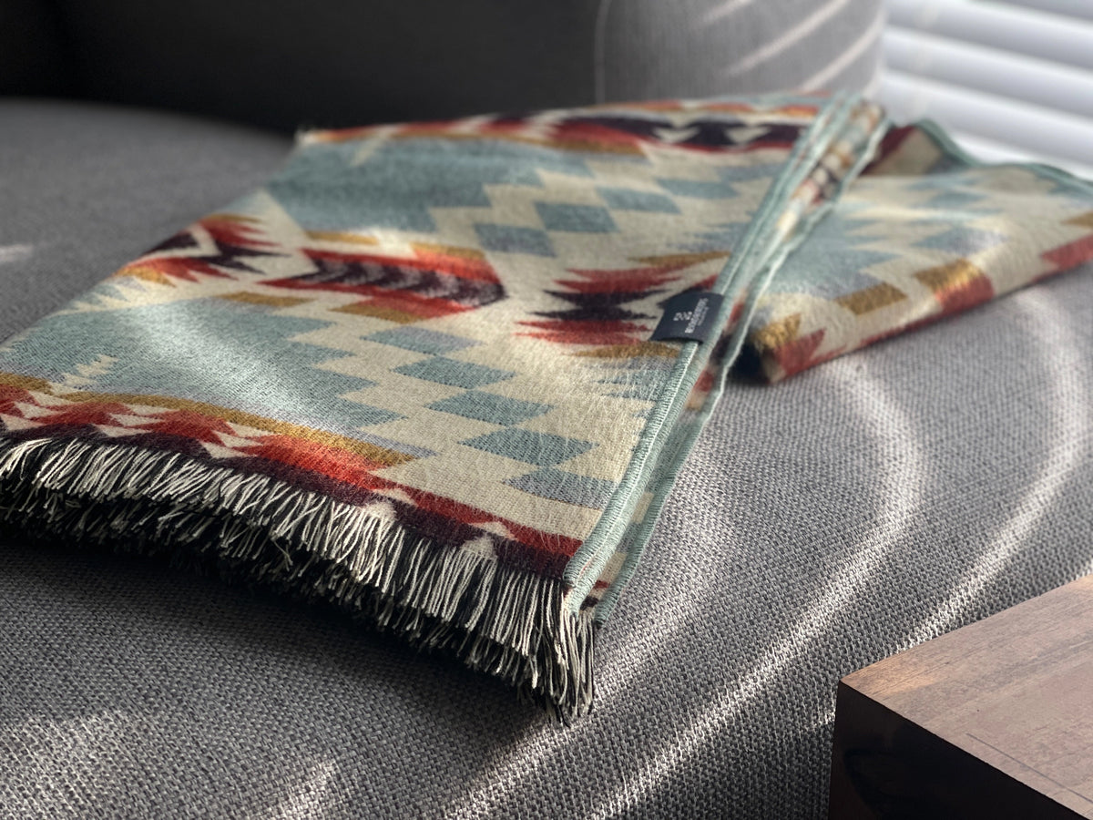 Secoya Throw in vibrant mint with a geometric Southwestern pattern and fringed edge by Bungalow Furniture &amp; Accessories.