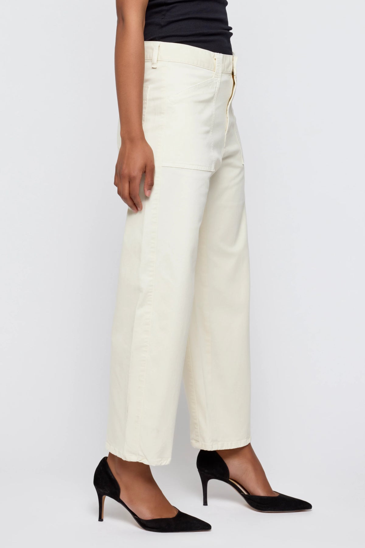 A person models the Pomonok Gusset Cargo wide-leg jeans by Moussy, paired with black pointed-toe heels, standing sideways against a plain light background.