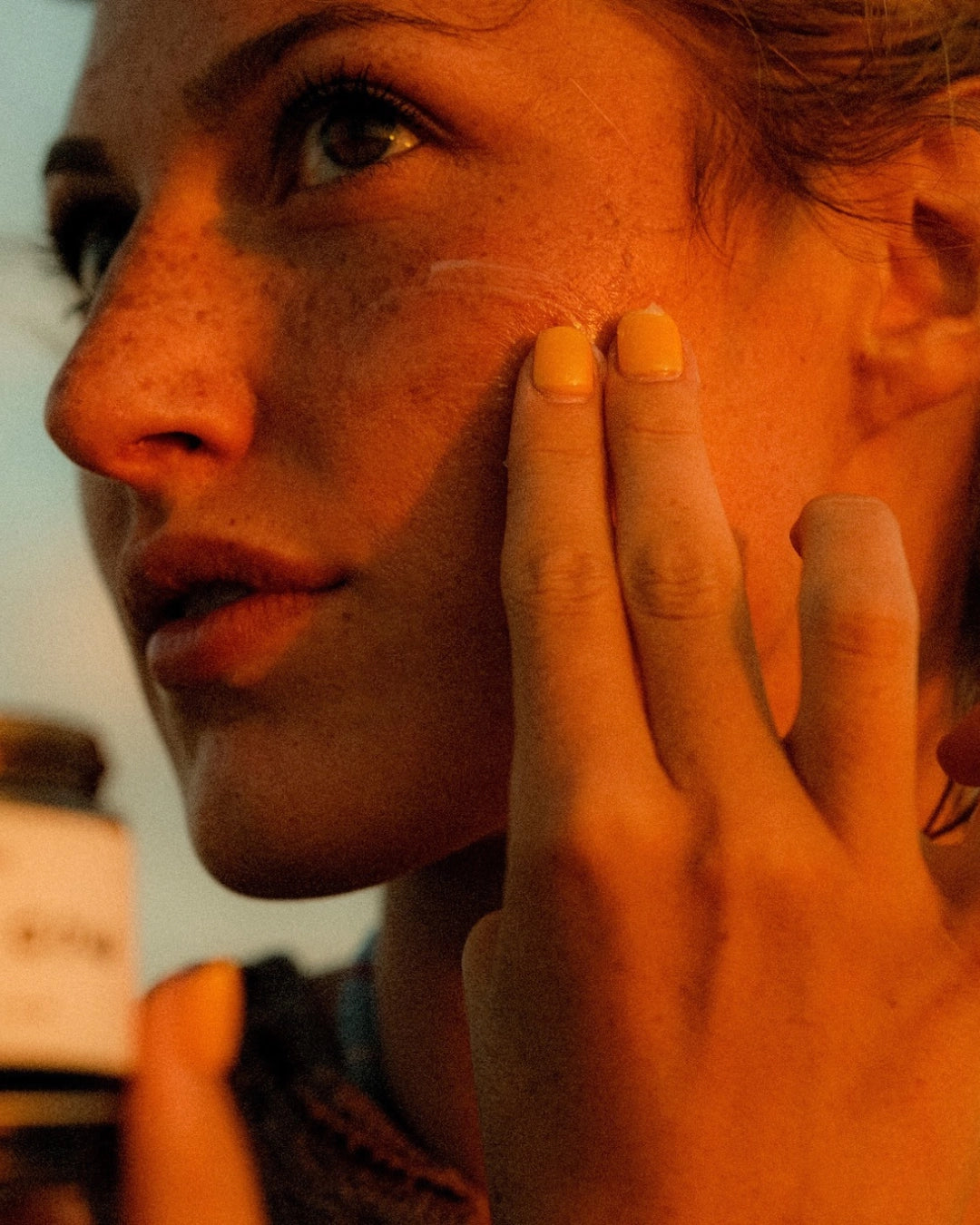 Faire SC Whipped Tallow Moisturizer being applied to a woman’s cheek with her fingers.