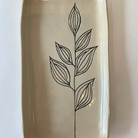 The Floral Small Tray by Faire features a hand-etched black leafy branch on a cream ceramic base, adding botanical charm to your table.