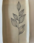 The Floral Small Tray by Faire features a hand-etched black leafy branch on a cream ceramic base, adding botanical charm to your table.
