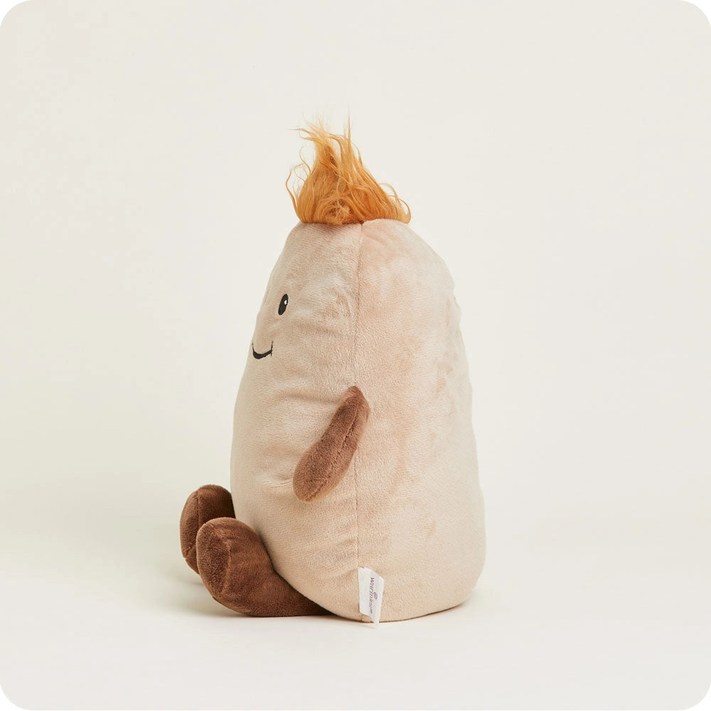 The Faire Potato Warmies is a microwavable plush shaped like a smiling beige potato, featuring brown arms and legs plus an orange tuft of hair, shown sitting upright against a plain white background.