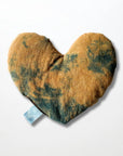 The Faire Heart Eye Pillow is a heart-shaped cotton pillow with a brown and dark green tie-dye pattern and a small blue tab—ideal for gentle anxiety relief. Shown on a plain white background.