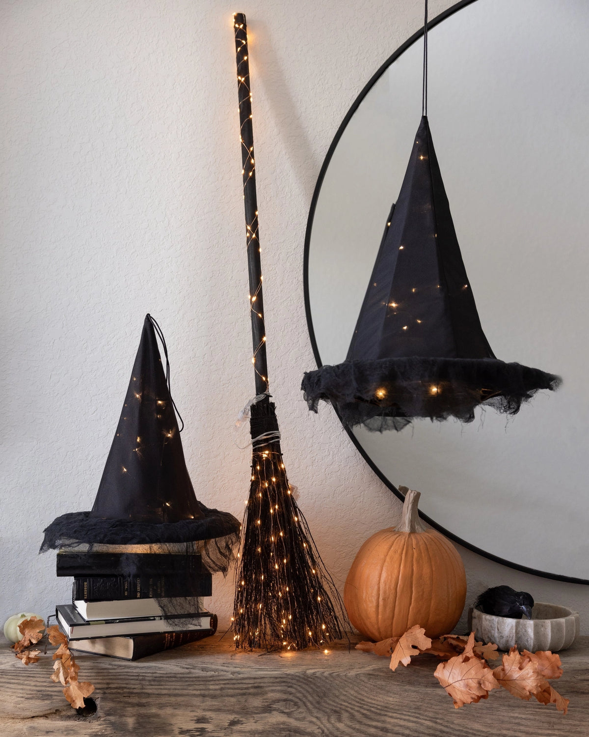 Light-up witch hat centerpiece with pumpkins and leaves, Halloween decor by Faire for Bungalow Furniture.