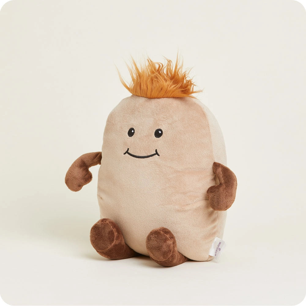 Potato Warmies by Faire is a microwavable plush toy shaped like a potato with brown arms and legs, spiky orange hair, and a smiling face, offering sensory comfort while sitting on a light background.