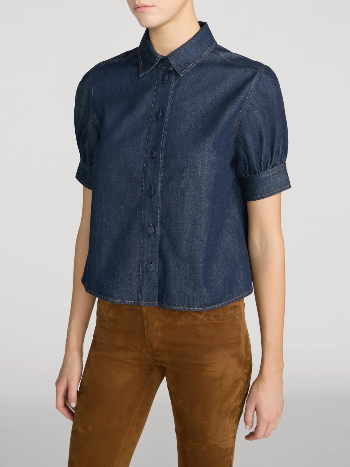 FRAME The Poise Top in lightweight denim with structured sleeves and pointed collar, styled with brown pants.