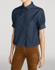 FRAME The Poise Top in lightweight denim with structured sleeves and pointed collar, styled with brown pants.