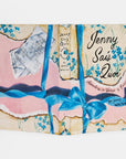 Jenny Sais Quoi book with pink and blue ribbon, floral design, vintage ticket cover by Hachette Book Group.
