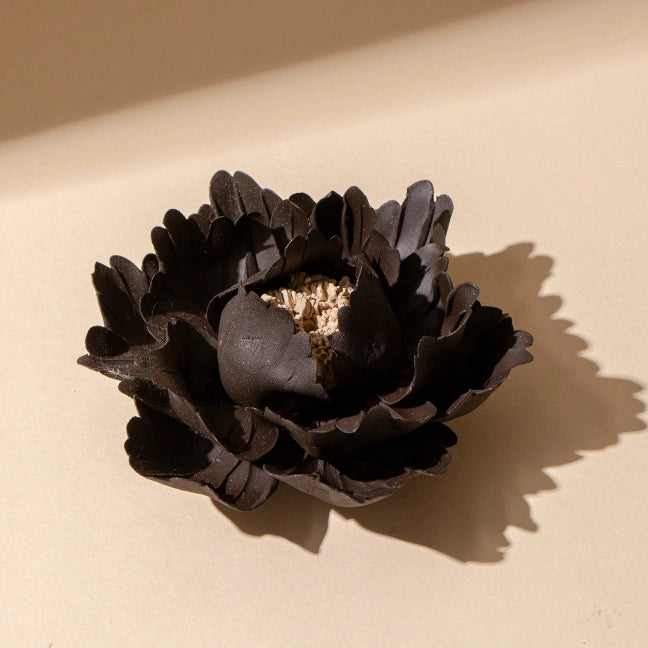 The Faire Ceramic Anemone Incense Holder features sculpted, layered petals in dark brown with a textured center and a rustic glaze, capturing traditional Chinese charm as it rests on a light beige surface casting a soft shadow.