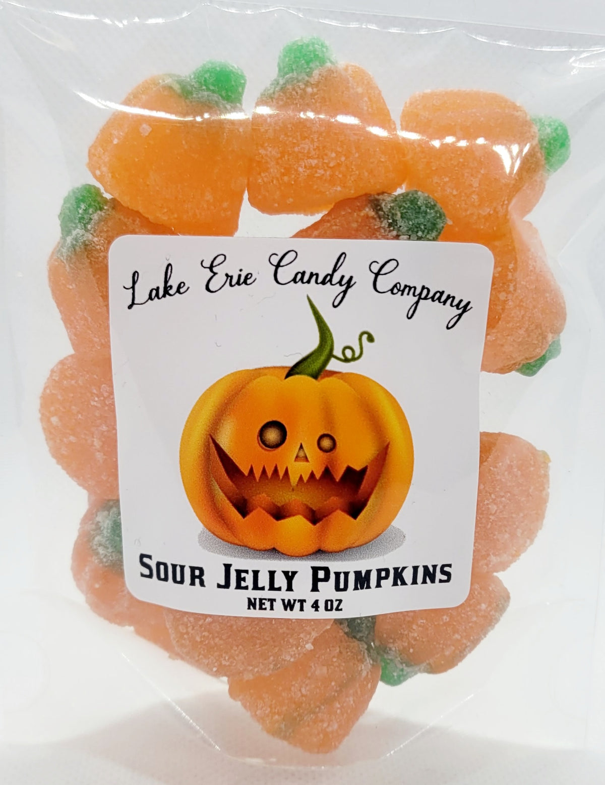 Faire Sour Jelly Pumpkins with green stems in a jack-o’-lantern labeled plastic bag.