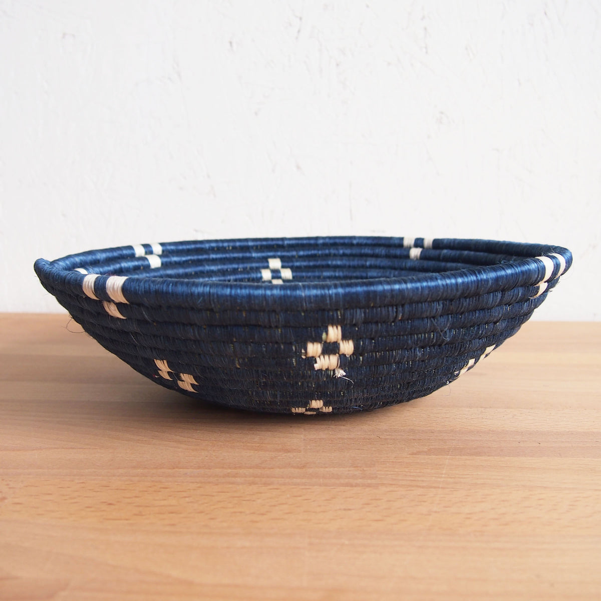 Dark blue and beige patterned Kabaya Large Bowl by Faire displayed on a wooden surface.