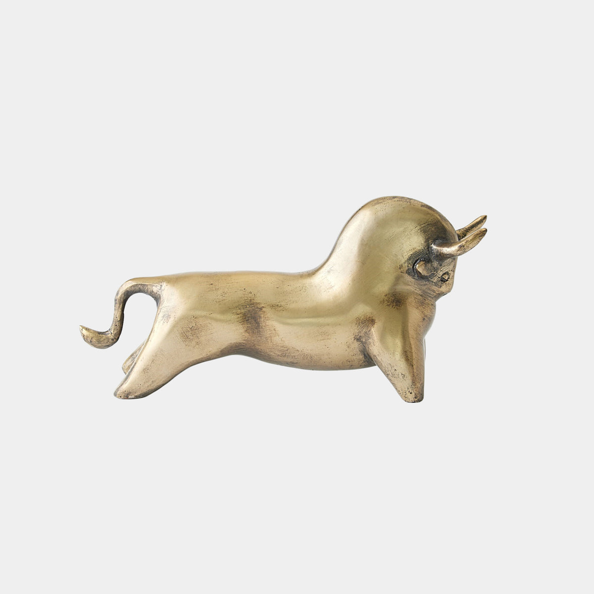 Antique brass bull sculpture with curved horns and raised tail by Global Views, Sampson collection on white background.