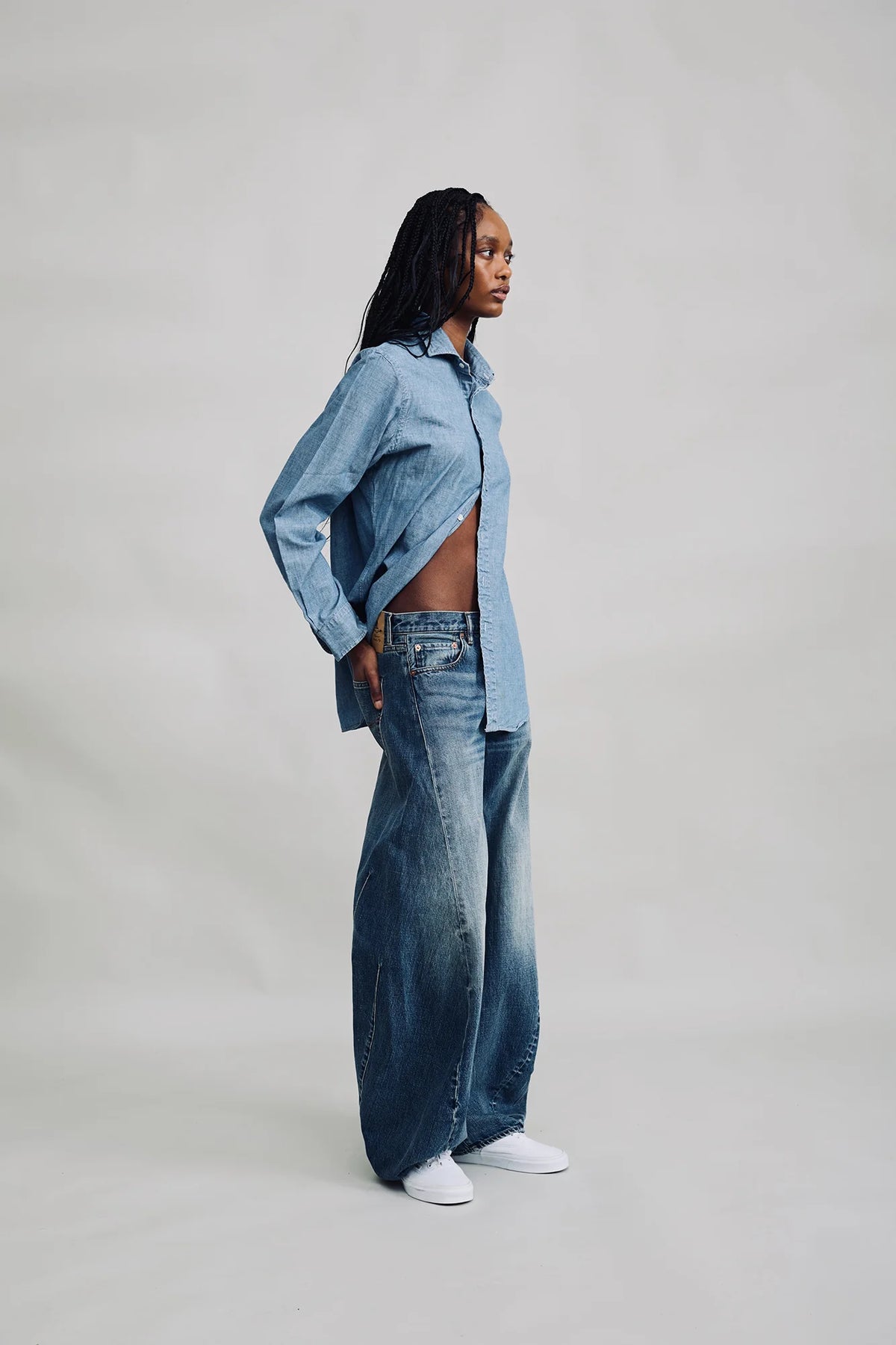 Denimist REMY BARREL JEAN and indigo denim shirt, worn sideways, set against a neutral gray background.