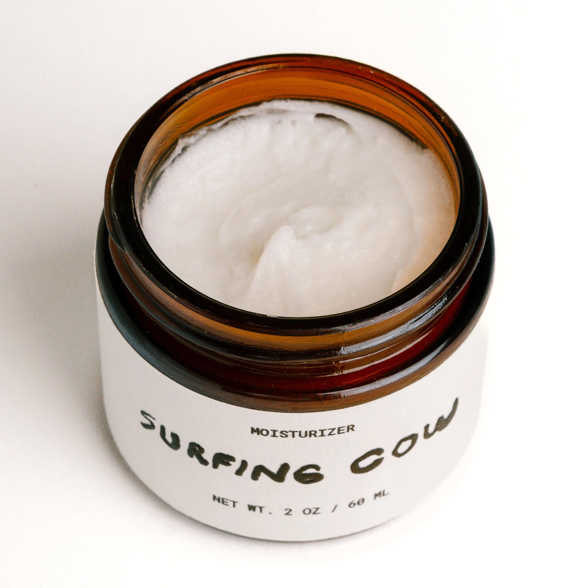 Whipped tallow moisturizer in an open amber glass jar by Faire SC.