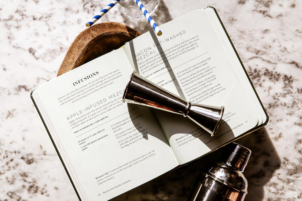 Mezcal and Tequila Cocktails book by Harper Collins with cocktail tools, styled on a bar at Bungalow Furniture & Accessories.
