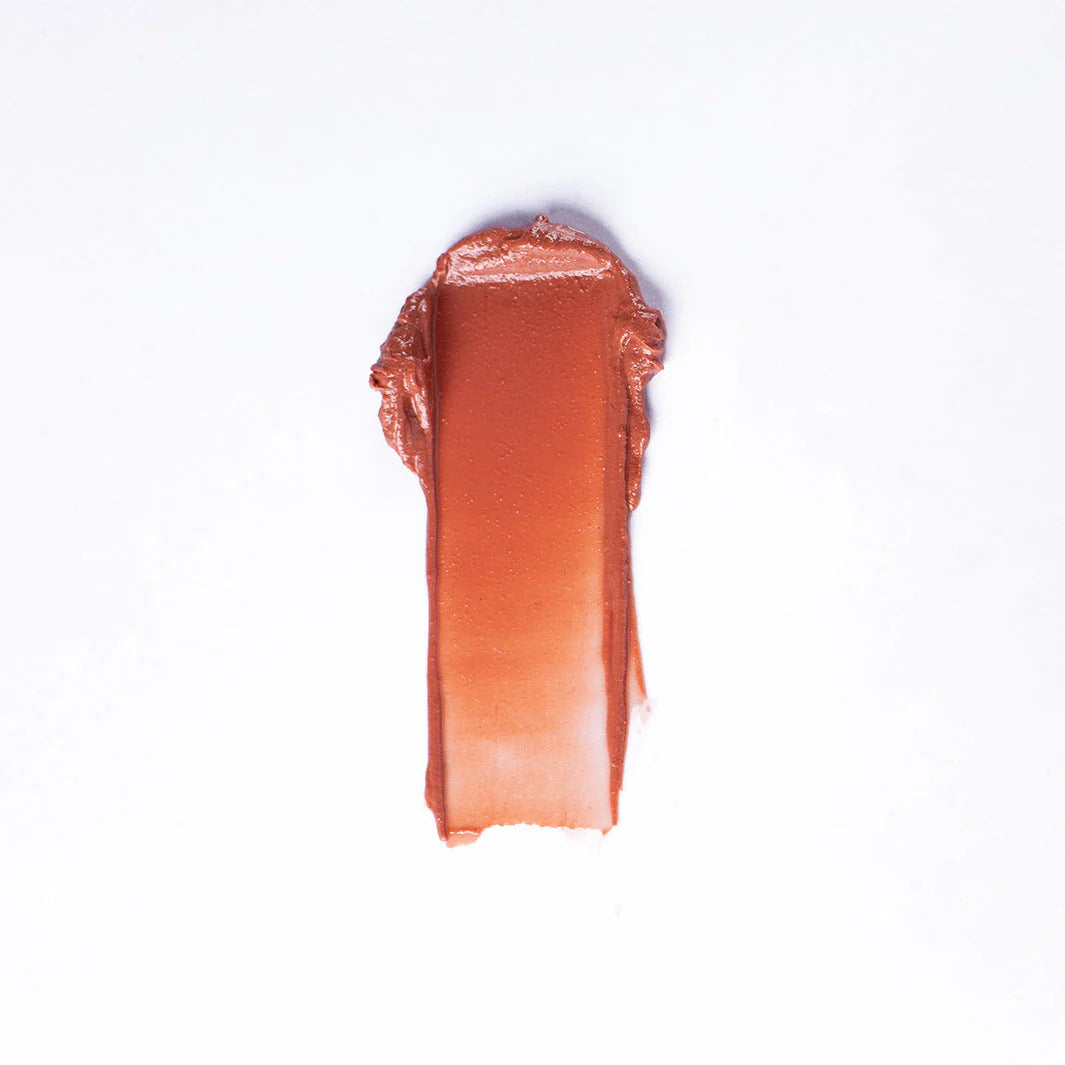 A rectangular swatch of Faire 01 Tinted Lip Balm & Blush, a creamy, reddish-brown hydrating formula, is smeared on a white background.