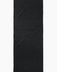 The Faire Leopard Yoga Towel, an ultra-absorbent black towel with a subtle textured pattern and visible wrinkles, is shown vertically against a white background.