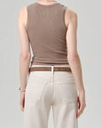 A person is seen from behind wearing the Citizens Of Humanity/AGOLDE nova tank, featuring a scoop neckline, paired with high-waisted off-white jeans. Their arms rest naturally at their sides against a plain light gray backdrop.