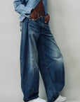 Denimist REMY BARREL JEAN in indigo denim styled with white sneakers, casual and modern look against plain backdrop.