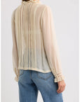 Sheer cream Magdeleine Top with lace ruffles by DOEN, styled casually with blue jeans, back view.