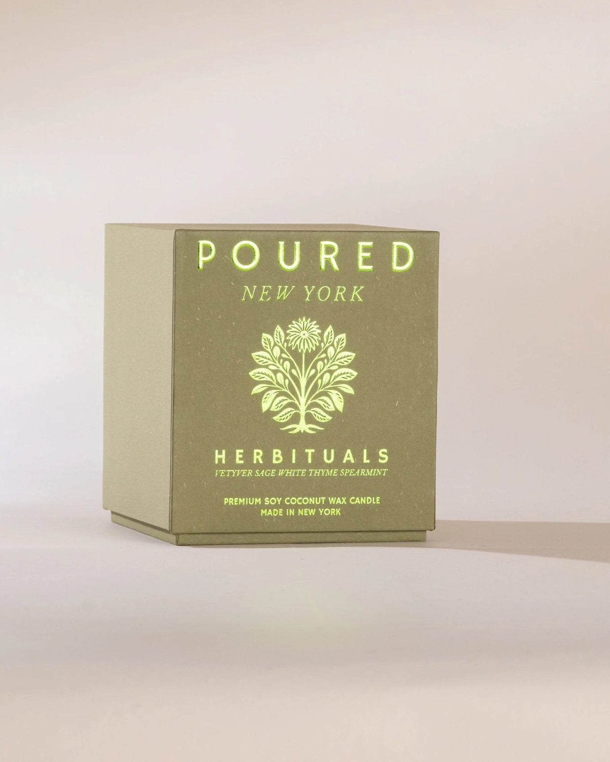 Herbituals olive green candle box with botanical pattern and yellow text, herbal scent by Faire.