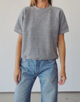 Hey Gang S/S Sweatshirt in light fabric styled with blue jeans, shown against a neutral wall for a relaxed look.