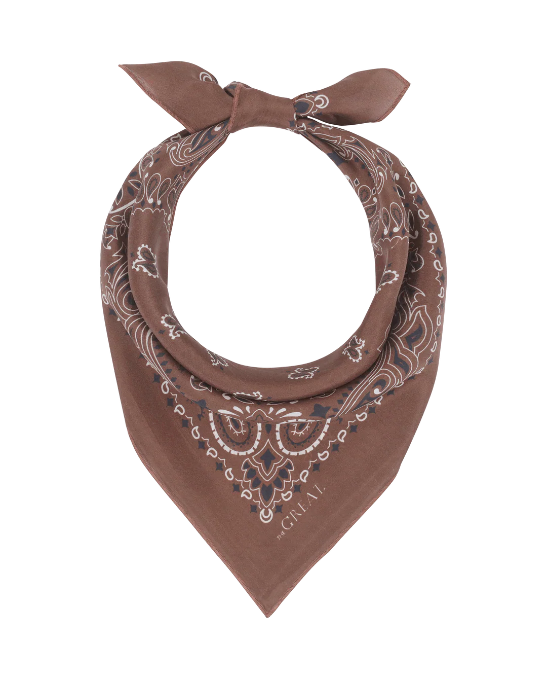 The Great Inc. presents The Silk Bandana, crafted from 100% silk and featuring white paisley patterns. It’s folded into a triangle and knotted at the top, showcased on a plain white background.