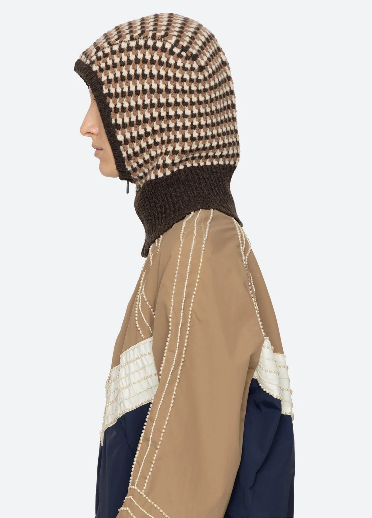 Tan jacket with white stitching and Sea New York DECLAN BALACLAVA, shown in a modern lifestyle setting.