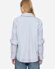 Oversized light blue Zayna Button Down with striped collar and cuffs, back view paired with jeans.