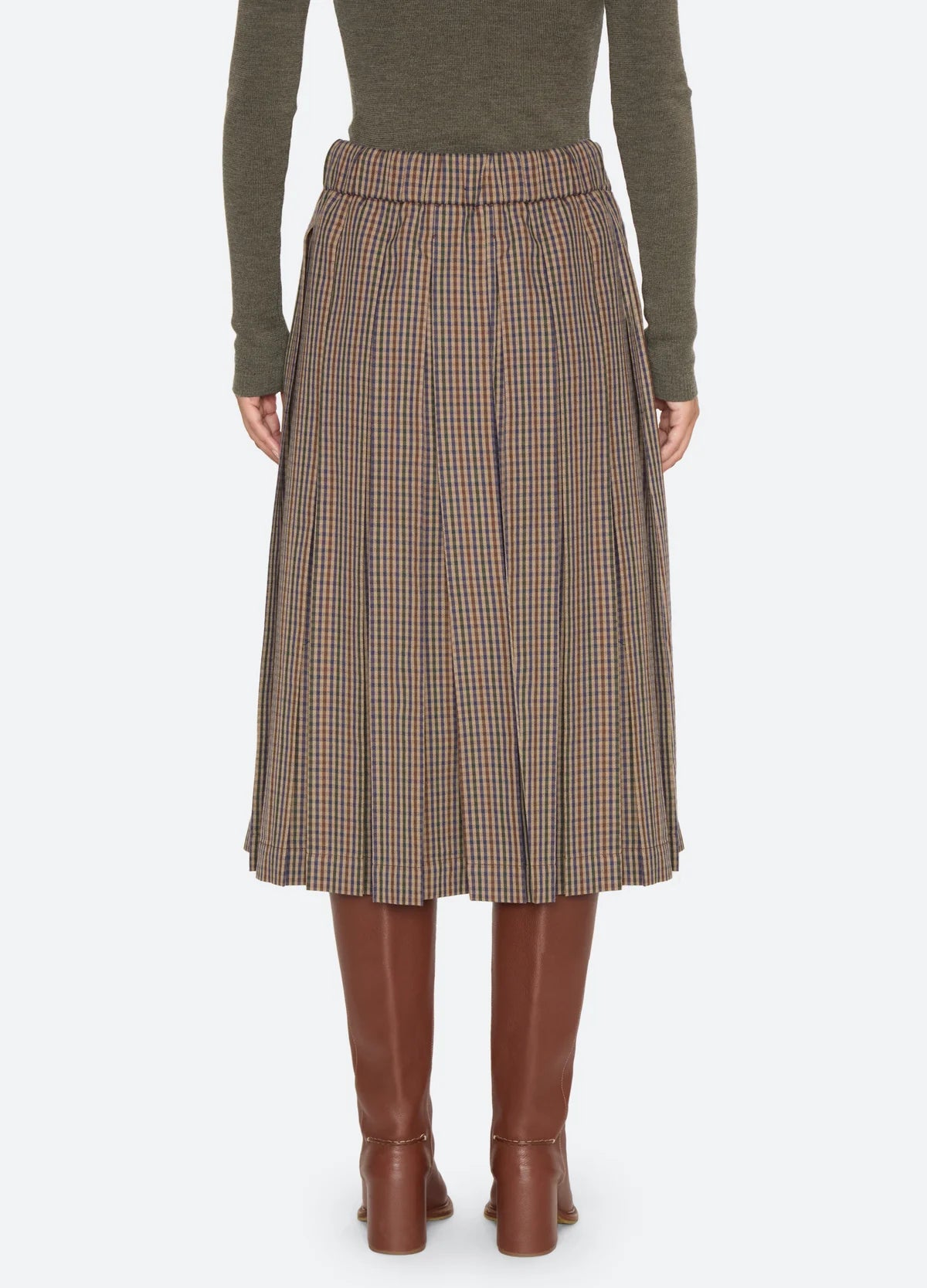 Julia Plaid Midi Skirt in a pleated style, viewed from the back with brown leather boots.
