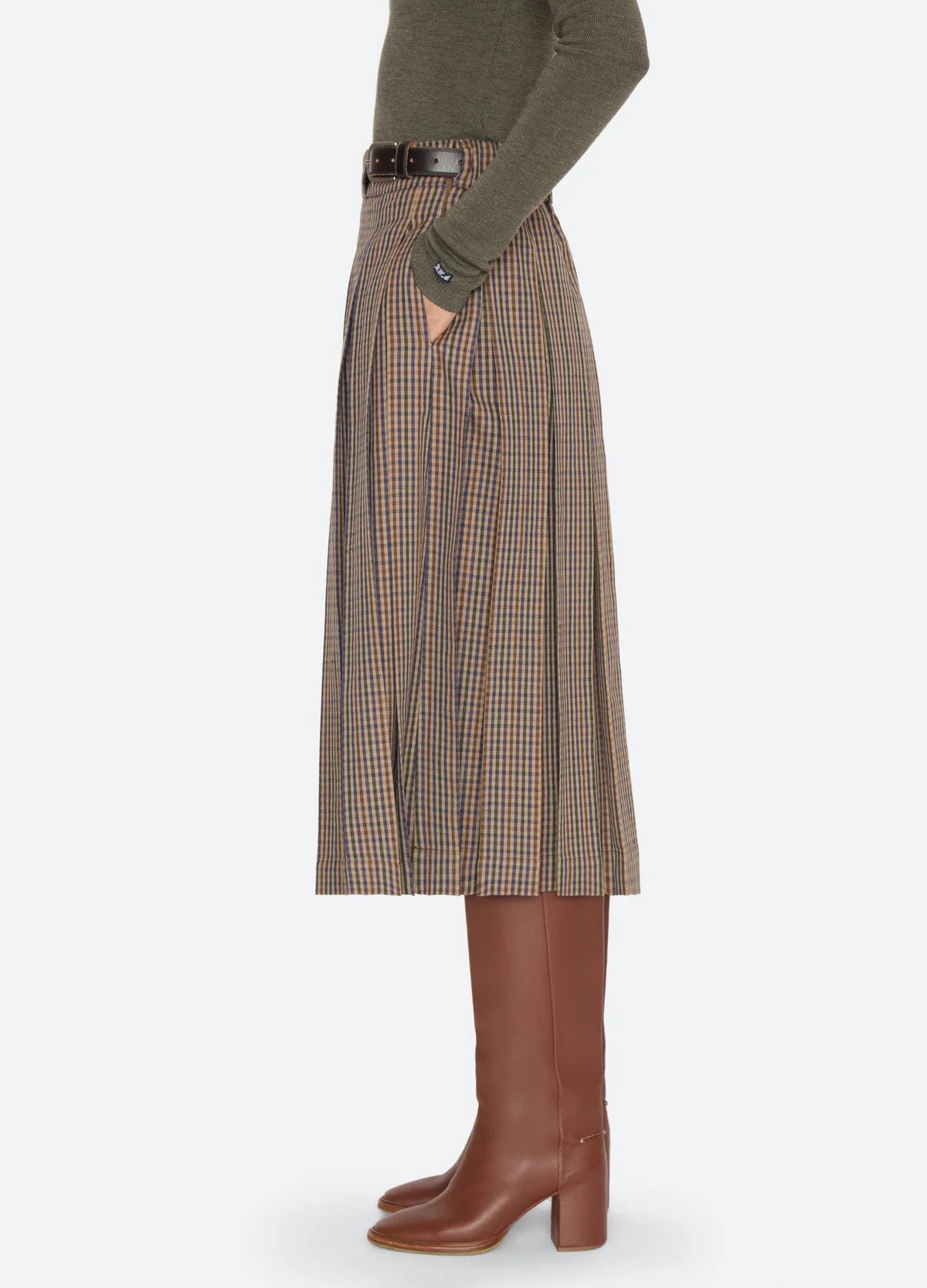 Julia Plaid Midi Skirt in a pleated side view, styled with a sweater and brown leather boots.